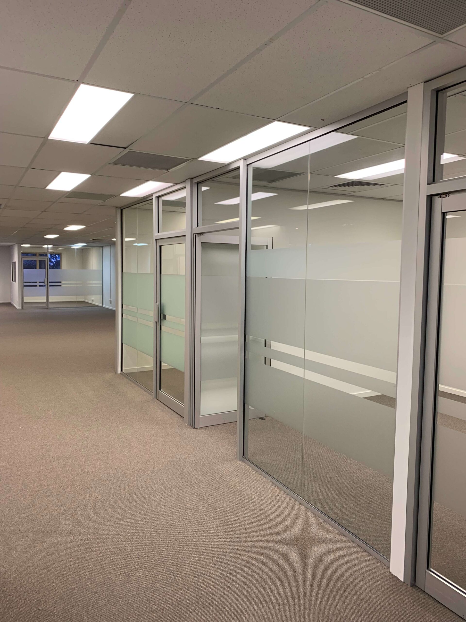 AGG Services modern office aluminium glass partitions with frosted decal and glass doors.Creating an open and professional workplace environment for productivity